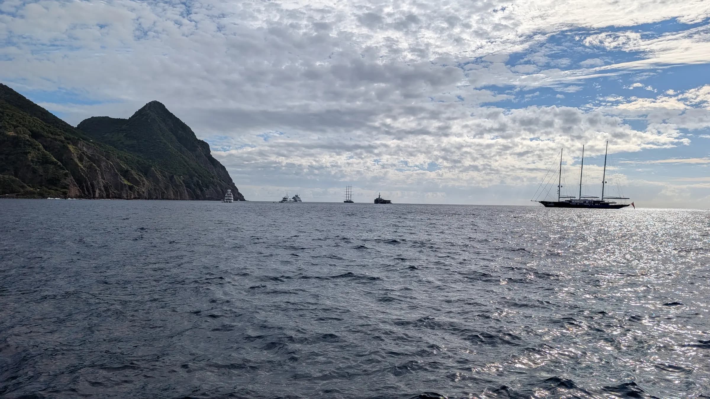 Yachts at anchor in Ladder Bay with the island of Saba rising behind them