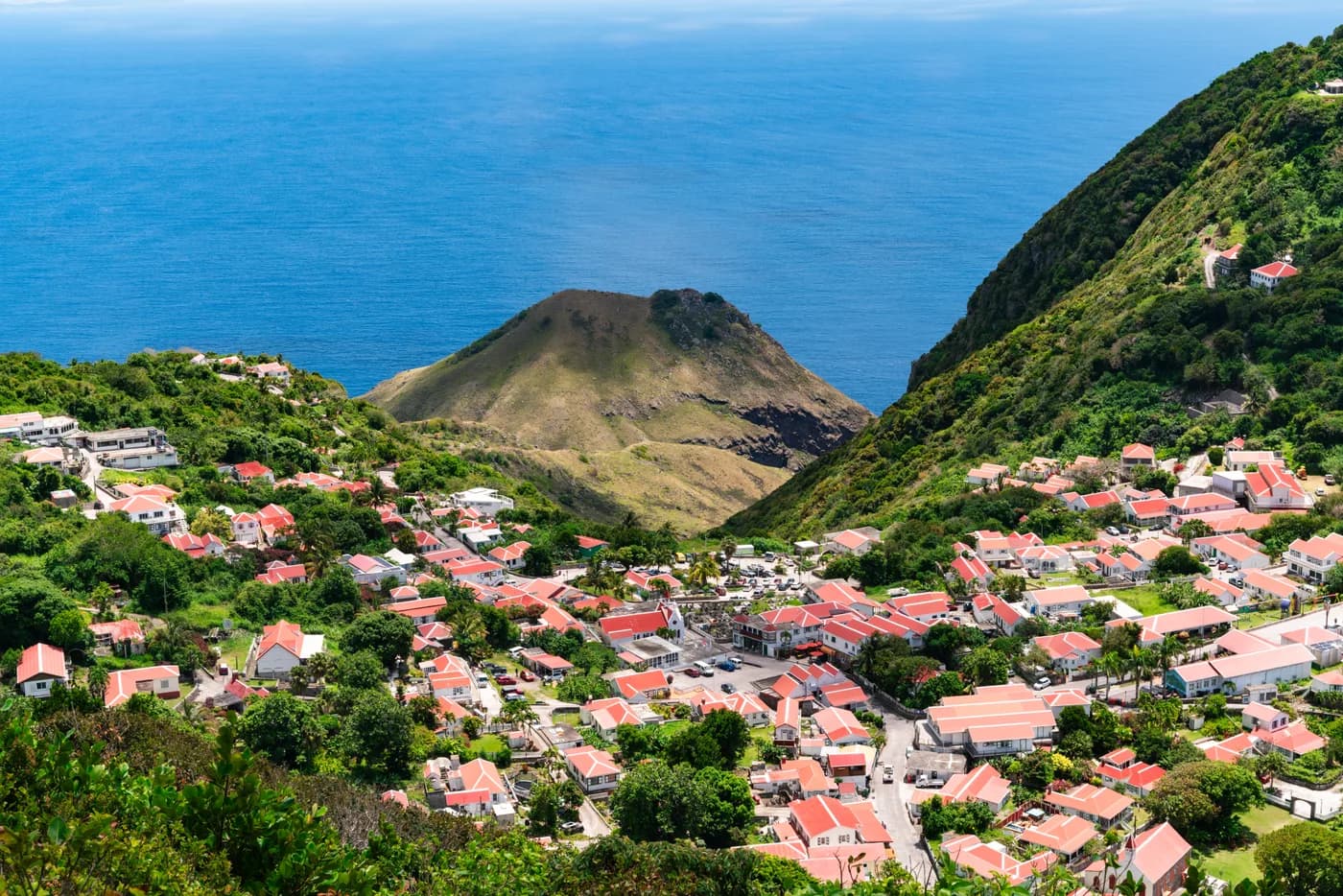 Colorful red-roofed cottages of Windwardside village on the green hillside of Saba.